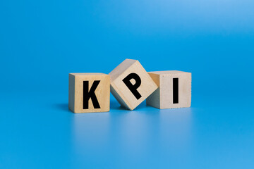 KPI letter symbol on wooden blocks isolated on blue background. concept of business key performance...