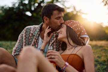 Loving couple relaxing in park while waiting for open air music festival.