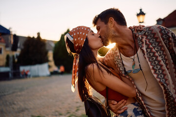 Affectionate couple kissing at summer sunset.