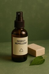 A close-up shot of an insect repellent spray bottle, a bar of soap, and a leaf on a green background