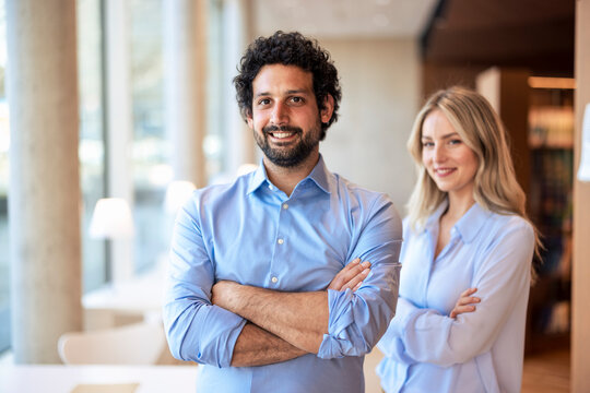 Smiling colleagues with arms crossed in university