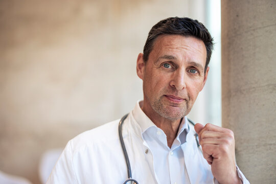 Mature doctor clenching fist in hospital