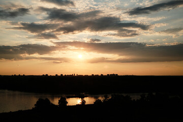 Summer sunset over Belgrade, Serbia, with a dramatic sky and city skyline silhouetted against the...