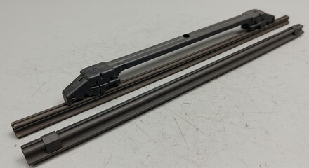 Machining Tool Part Metal Slide and Rails on Light Gray Surface