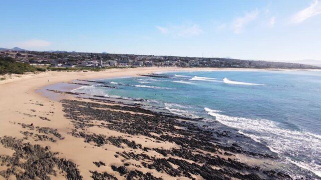 Surfers paddle out from Jeffreys Bay main beach on scenic Sunshine Coast