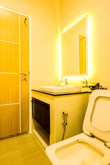 Home Decoration Series : Modern bathroom decoration with high ceiling and warm white lights. Bathroom interior with a simple style design. Toilet of a minimalist style house.