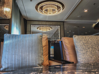 Cozy living room atmosphere inside bar lounge bistro onboard luxury all inclusive yacht cruiseship cruise ship liner in contemporary Art Deco interior design	