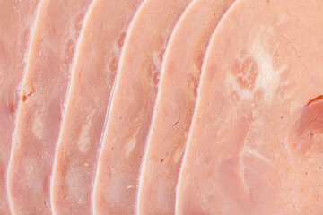Slices of ham, thinly sliced sausage. Ham texture background. Close-up, top view.