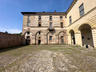 The grand historic Visconti Castle of Melegnano stands majestically behind a lush green park on a...