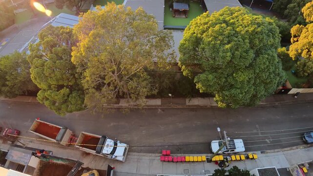 Timelapse of a busy neighborhood street with cars passing by and a truck carrying earth from nearby construction
