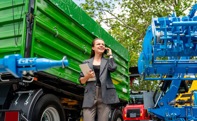 Modern multitasking businesswoman with tablet and phone at agricultural equipment dealership