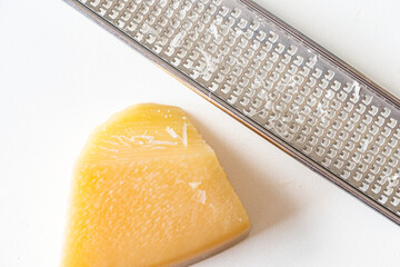 Parmesan cheese and cheese grater on a white background. View from above. Close-up.