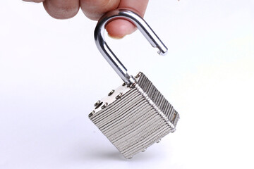 Fingers holding a padlock isolated on a white background.