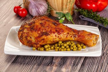 Baked turkey drumstick served green peas