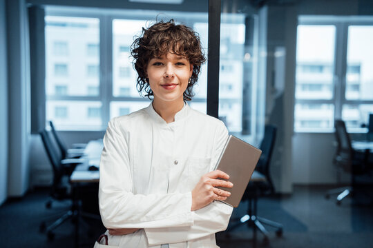 Smiling doctor standing with tablet PC at hospital