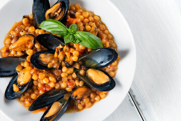 Fregula con cozze, tipica pasta sarda, cibo italiano 