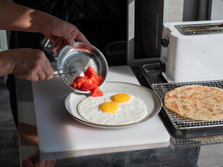Chef serves fried eggs in a cafe. 