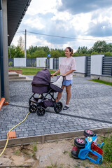 young mother with a stroller doing her daily chores near her private house