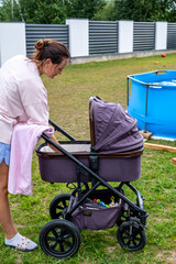 young mother with a stroller doing her daily chores near her private house