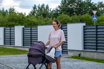 young mother with a stroller doing her daily chores near her private house