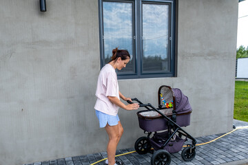 young mother with a stroller doing her daily chores near her private house