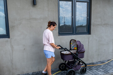 young mother with a stroller doing her daily chores near her private house