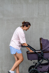 young mother with a stroller doing her daily chores near her private house