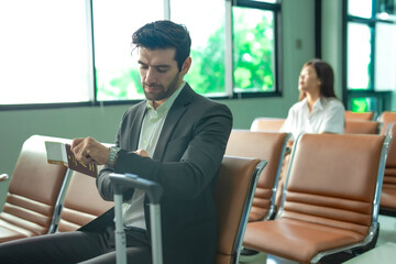 Male office worker in a waiting space looking emotionally drained, expressing fatigue and workplace...