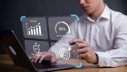 Man using laptop with transparent display showing business performance data