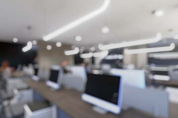 Blurred modern office interior with open space design. Rows of workstations and minimalistic lighting fixtures create a contemporary business environment.