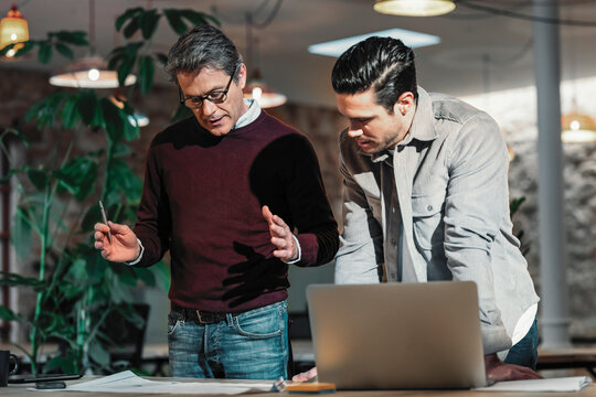 Architect father and son discussing in office