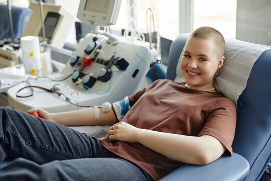 Smiling woman lying on couch donating blood