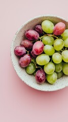 Still life composition of ripe red and green grapes in a porcelain bowl on a plain solid background. Juicy texture and spotted skins highlight organic flavor and nutritious, aesthetic snack display.