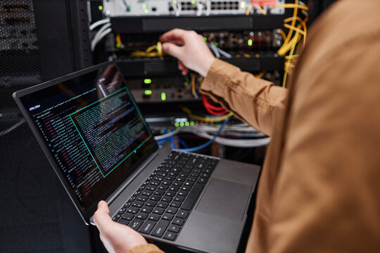 Administrator with laptop working in server room