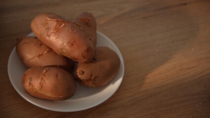 Close-up of boiled unpeeled potatoes stacked on plate