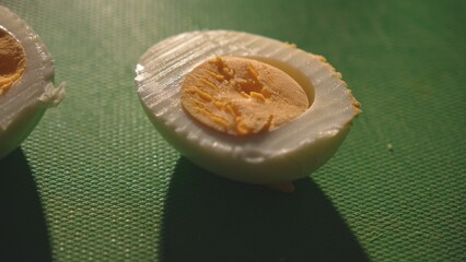 Egg halves with yolk on green cutting board