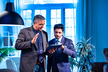 Indian businessmen collaborating on tablet for project planning in professional office space