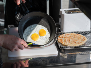 The chef fries the eggs sunny side up. 