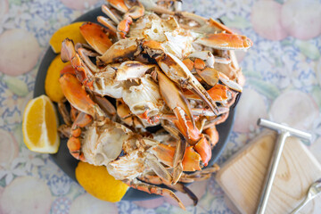 Freshly steamed blue crabs served with lemon wedges on a table