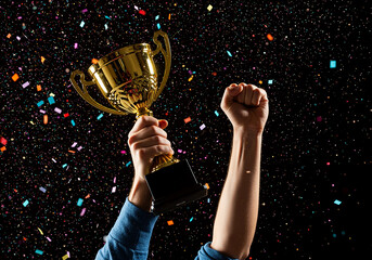 A moment of pure triumph as a winner raises a golden trophy cup amidst a shower of colorful confetti, symbolizing ultimate success and achievement.