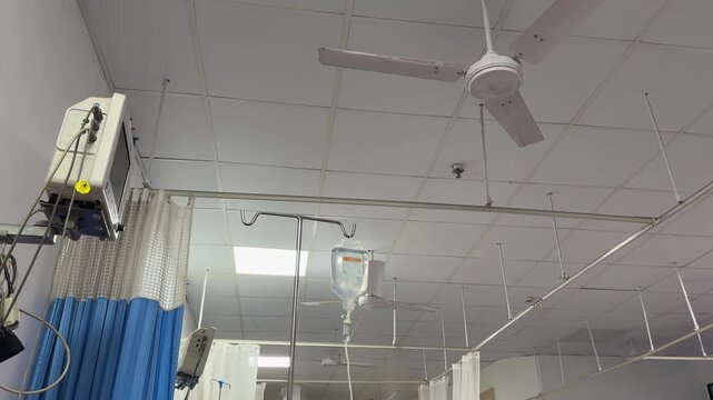 A point of view shot from a patient's perspective in a hospital bed showing the ceiling and the fan
