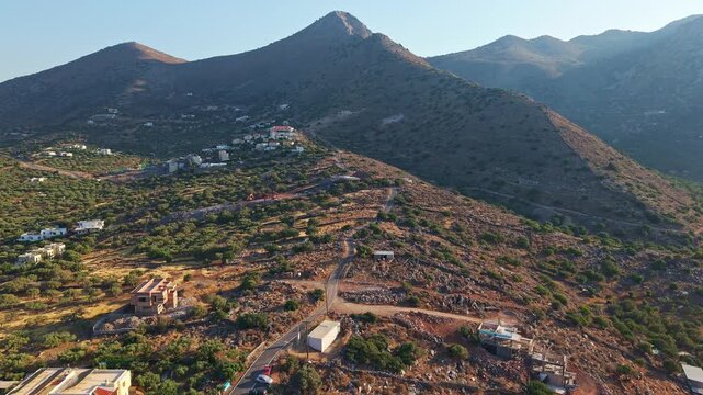 Aerial drone view of Mount Oxa and Elounda town in Crete during golden hour.
