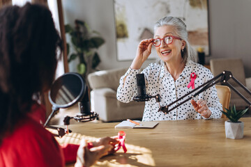 Radio host interviewing guest about breast cancer awareness in studio