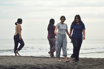 Four girls stroll along the shoreline, chatting and soaking in the beauty of the ocean view and the gentle morning ambiance.