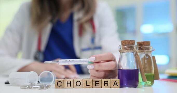 Woman holds thermometer near blocks with Cholera and bottles with colorful reagent liquids. Diagnosing and managing cholera in modern clinical setting