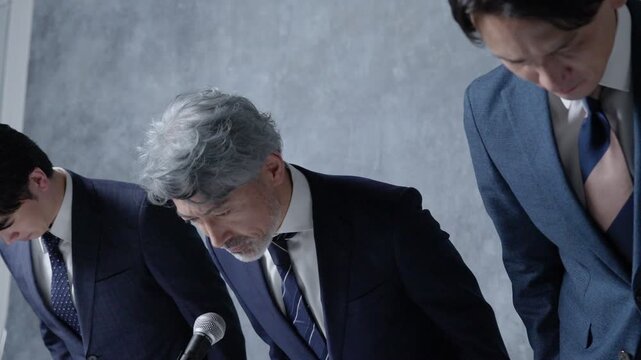 謝罪会見をするビジネスマン