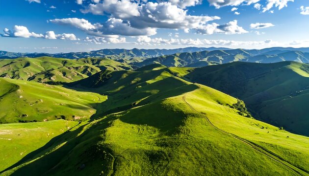 Lush green rolling hills under a vibrant blue sky with fluffy clouds