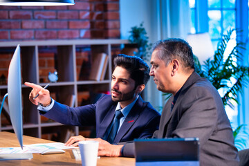 Young Indian professionals work together on computer in office, planning project as a team