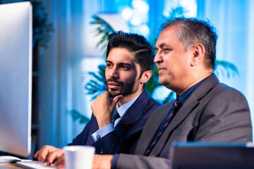 Young Indian professionals work together on computer in office, planning project as a team
