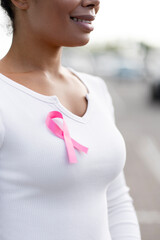 Woman wearing pink ribbon showing support for breast cancer awareness